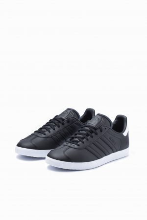 Pair of Adidas Gazelle trainers in black leather with white stripes, front view