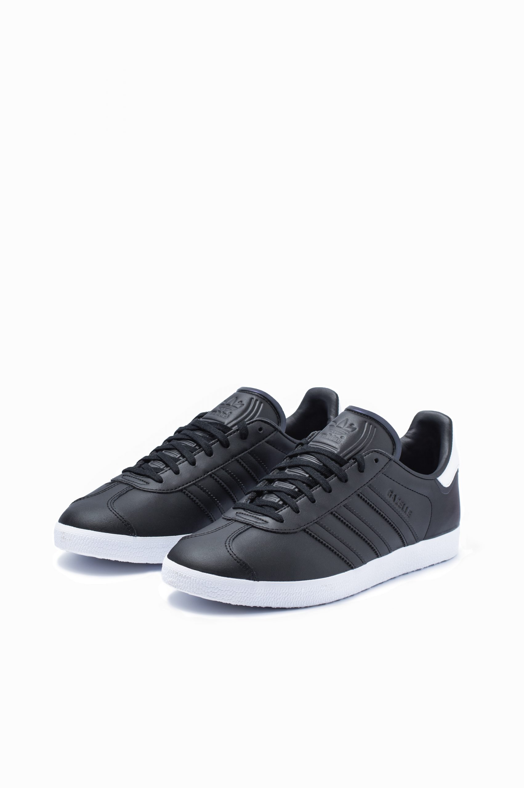 Pair of Adidas Gazelle trainers in black leather with white stripes, front view