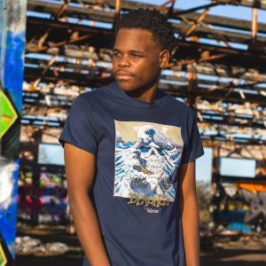 Man wearing Deadhedz Wavez t-shirt with Hokusai wave print, urban industrial background